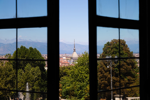 Turin - Italy - Urban skyline with Mole Antonelliana building, blue sky and Alps mountains.