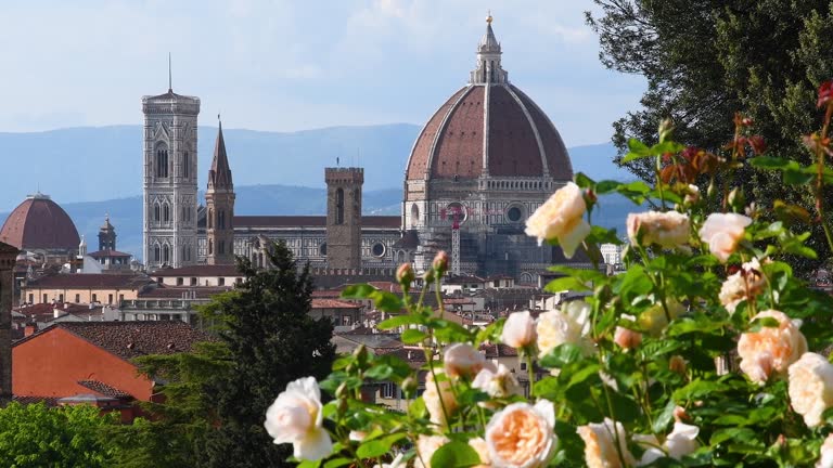 Famous Cathedral of Santa Maria del Fiore in Florence with blooming yellow roses on the foreground. Italy