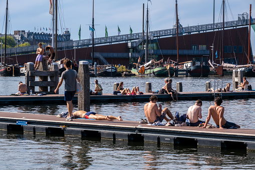 Amsterdam, The Netherlands - 6 September 2022: People bathing at the Marineterrein's inner harbour