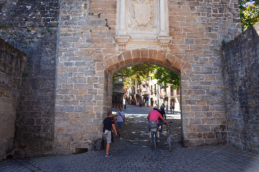 Pamplona, Spain - July, 31: Cyclists arriving through the medieval French Gate, in Spanish Portal de Francia