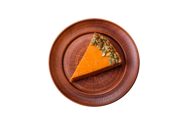 istock Beautiful tasty pumpkin pie with slices on a black ceramic plate 1636009026