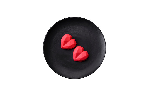 Delicious sweet heart shaped chocolate candies on a dark concrete background. Valentines day celebration