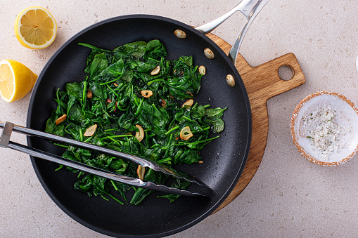 Sauteed spinach with garlic in a skillet, healthy side dish idea