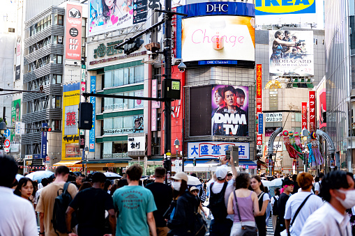 Shibuya Junction is the largest and most crowded pedestrian crossing in the world. It is seen here full of people and cars with the Tokyo streets and billboards on the background.