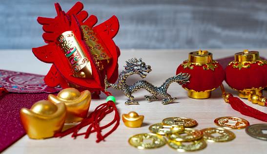 Chinese new year decorations and gold ingots or golden lump on wooden background. Still life.