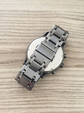 Rear view titanium wristwatch band on the wood table