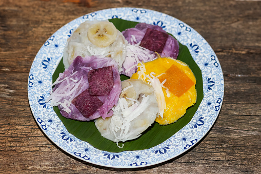 Dessert of Kind of thai sweetmeat put on old wooden in concept closeup style.served with coconut slices put on topped.