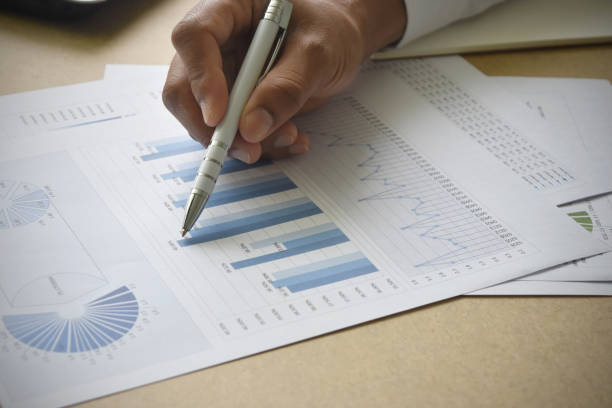istock businessman analyzing financial graphs and charts report on desk in office. 1636053796