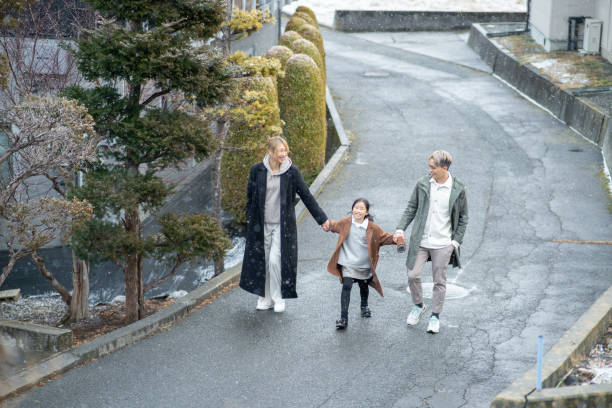 Asian Chinese family walking under snowing