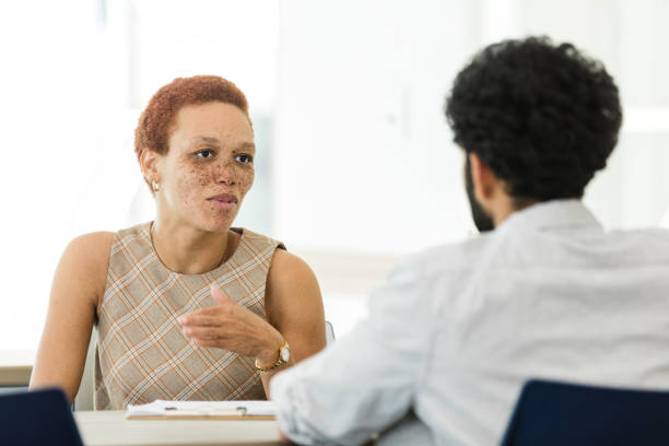 istock Mid adult female banker gestures while explaining account options 1636070061