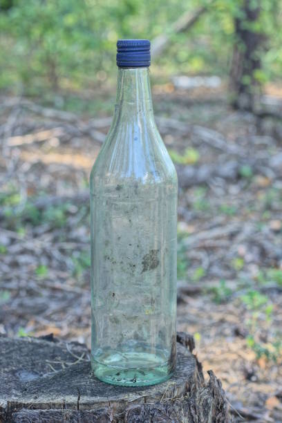 istock one old dirty white glass bottle stands on gray stump 1636077646