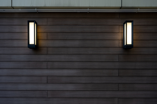 The wall lamp on the wooden wall at night