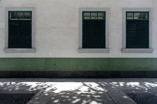 Orange colored façade and windows with shutters, residential building in Montagnola Park complex, Bologna, Italy