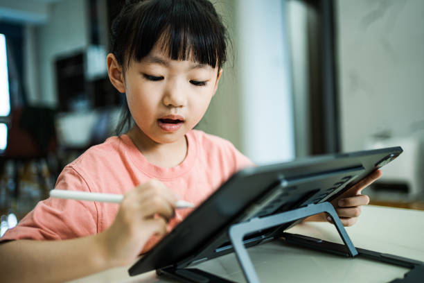 istock An Asian girl drawing on a tablet 1636117683