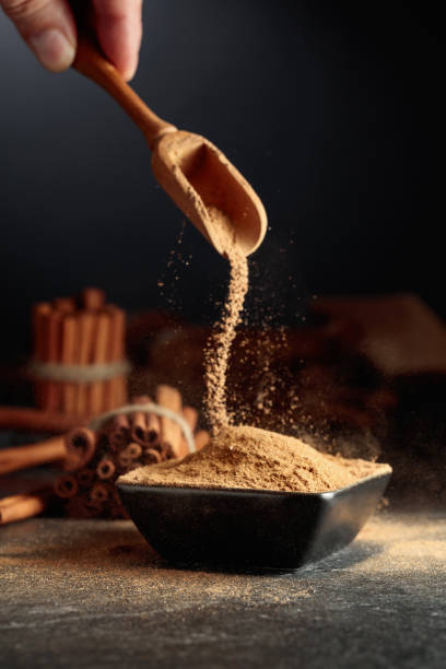 istock Cinnamon powder is poured into a black bowl. 1636118446