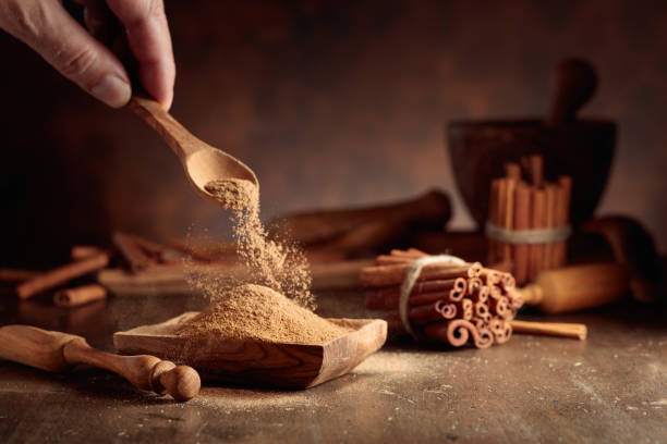 istock Cinnamon powder is poured into a wooden bowl. 1636118447