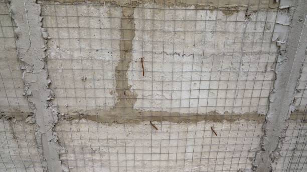 istock Cement fixing mesh attached to a rough cement wall. Application of putty on the reinforcing mesh, on the facade of the building. The construction surface of the facade wall of the building with a fixed mesh for cementing and painting the facade. 1636125586