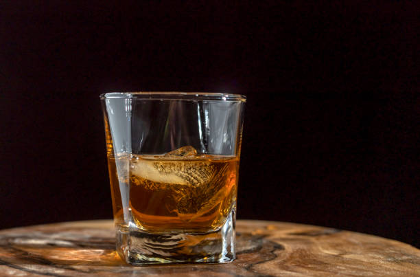 istock Whiskey, bourbon or cognac. Strong alcoholic drink with ice on a dark background. 1636128326