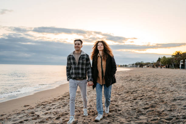 istock Young Couple Walking On The Beach 1636151888