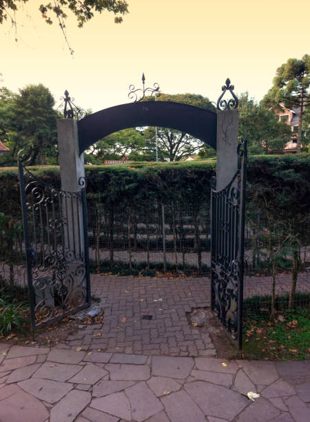istock Entrance to a park with iron gate and stone walkway. 1636153474
