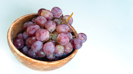 red grape in wooden bowl