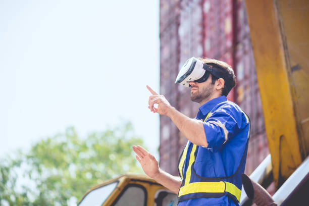 istock Engineer or technician worker wear PPE reflection cloth and virtual reality headset or VR glasses, acts like searching data in cloud database. Technology for helping logistic delivery management. 1636175116