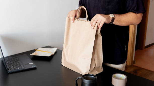 istock A worker packing a paper bag for shipping 1636183400