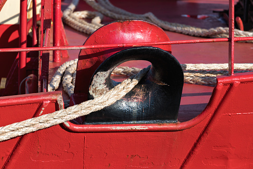mooring ropes through hawsehole of a freight ship