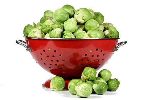 Brussels sprout in a vintage enamel sieve isolated on white background