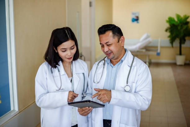 istock healthcare professionals in conversation, looking at digital tablet 1636195696