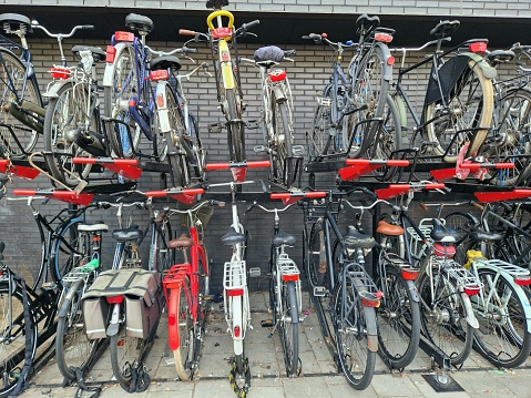 Large, full bicycle parking station in the Netherlands in front of modern building of Rotterdam central station