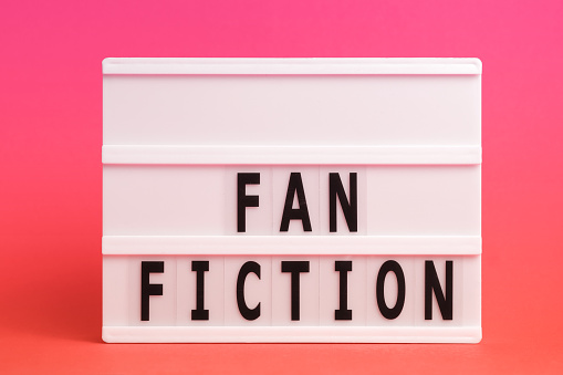 The word FANFICTION on lightbox isolated pink background. Literary Genres