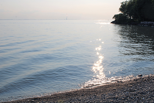 Catawba smooth rock beach on Lake Erie in Ohio, USA - sun on the sparkling water - reflection - beginning of a sunset