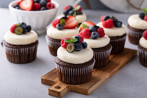 Chocolate cupcakes with cream cheese frosting and fresh summer berries