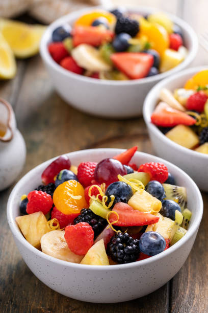 istock Fruit salad on a wooden table with berries and honey dressing 1636263094