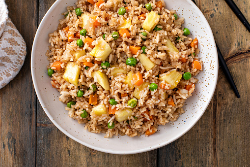 Pineapple fried rice with peas and carrots served in bowls
