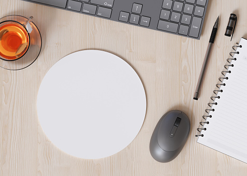 Blank and white, round computer mouse pad on the desk at home. Mousepad mockup. Copy space for your picture or text. Empty mouse mat ready for your design. Mock up, template. 3D render