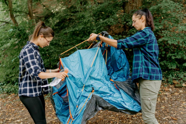 istock Two friends pitch a tent for a memorable camping adventure 1636287804