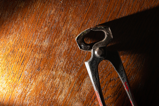 Close-up of a pair of pliers lying on a wooden table