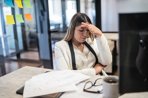 Worried young businesswoman working at office