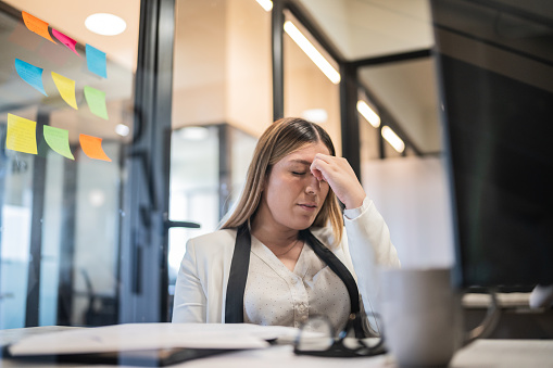 Worried young businesswoman working at office