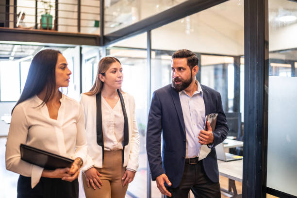 istock Coworkers talking while walking on the office corridor 1636335245