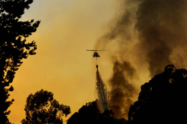 istock Helicopter Dropping Water on Out of Control Wildfire 1636341174