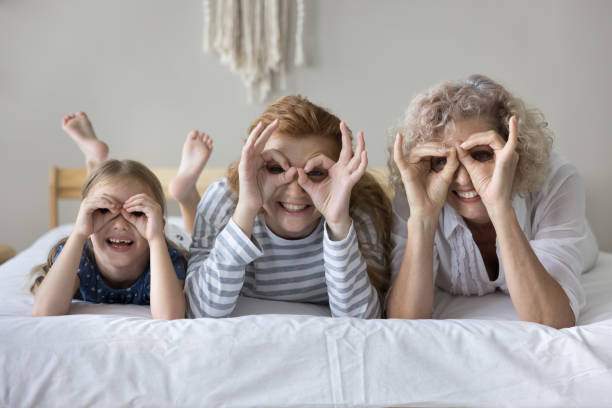 istock Cheerful kid, mom and granny having fun at home 1636342813