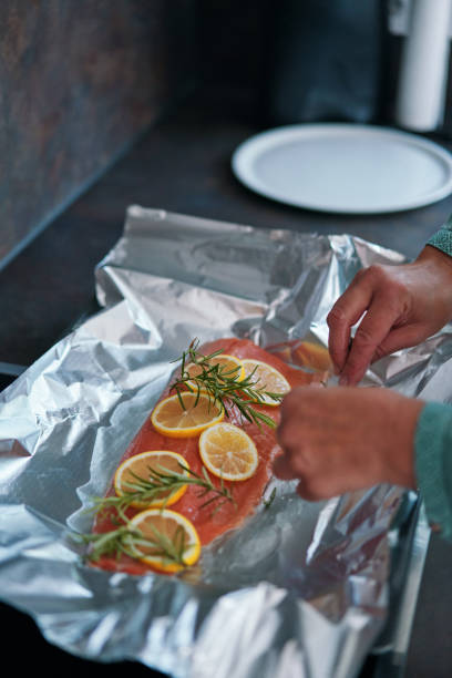 istock Preparing Salmon Fish Fillet with Lemon and Rosemary 1636376541