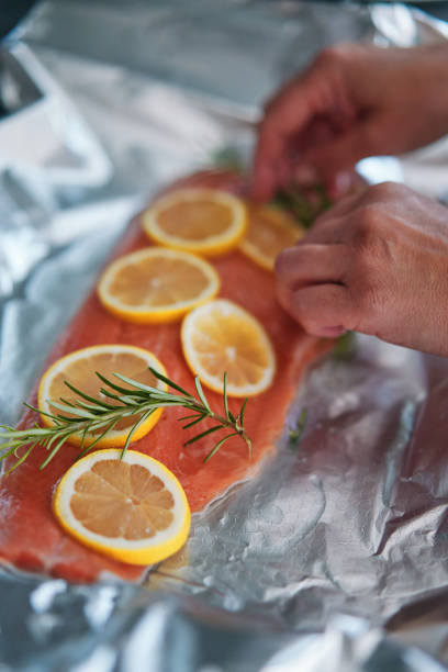 istock Preparing Salmon Fish Fillet with Lemon and Rosemary 1636376650
