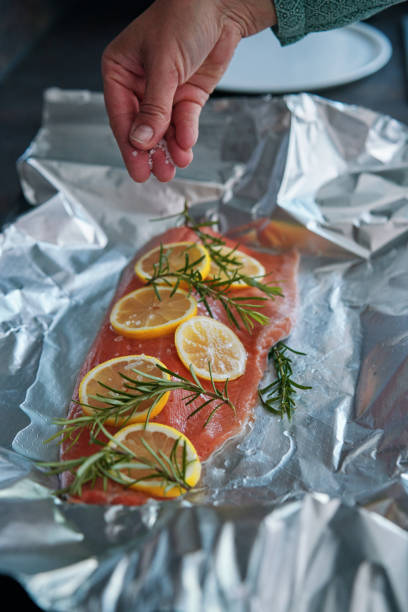 istock Preparing Salmon Fish Fillet with Lemon and Rosemary 1636376841