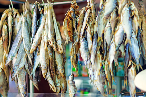 Dried fish hanging on hooks for sale