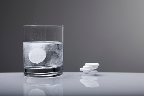 Aspirin paracetamol pill splashing into glass of water