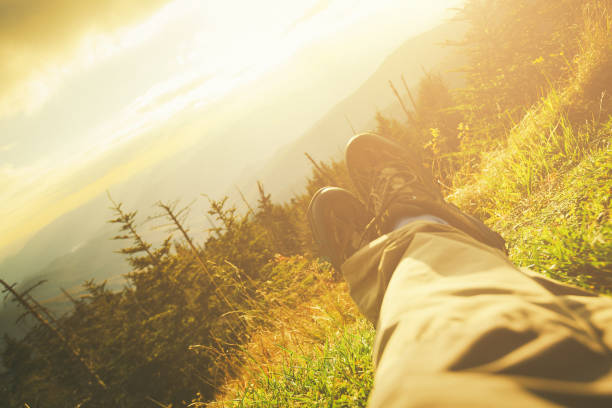 Man laying on the ground in a grass field. Horizontal Shot, focus on the grass.